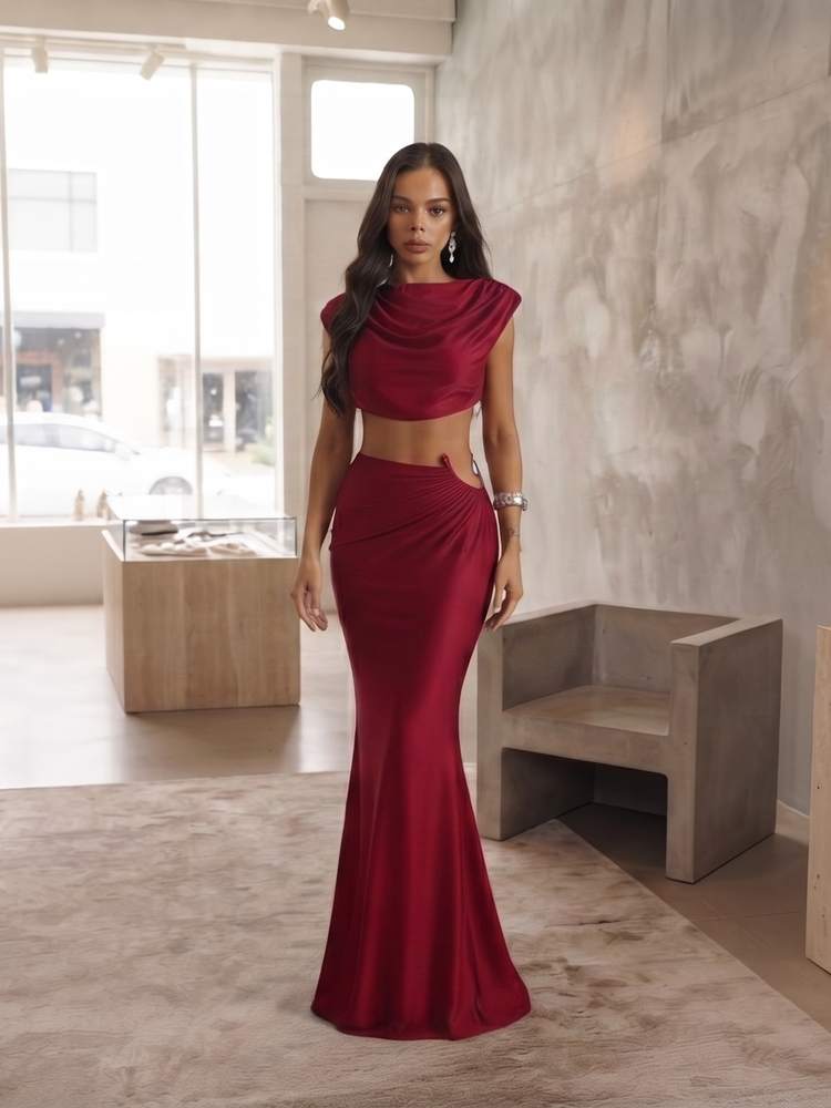 Modelo con top cowl de mangas cortas color vino y falda larga entallada con abertura en la cadera