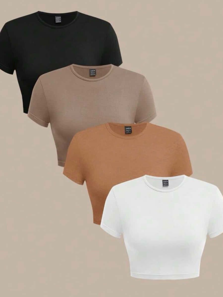 Cuatro crop tops de manga corta en negro, moka, camel y blanco sobre fondo beige