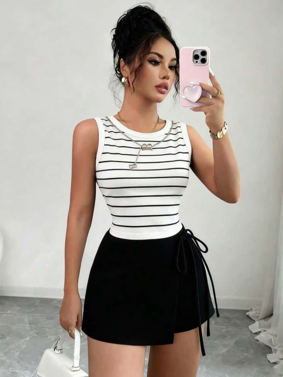Top sin mangas de rayas blancas y negras con falda-short negra de lazo al costado